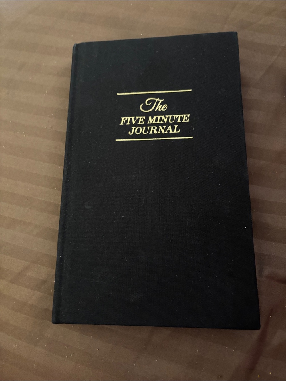 Free with purchase the  Five Minute Journal - Black Hardcover Journal